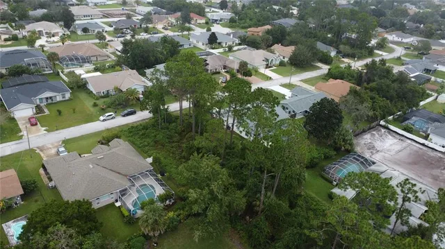 an aerial view of residential houses with outdoor space and trees