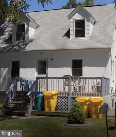 a view of a white house with a yard and lawn chairs