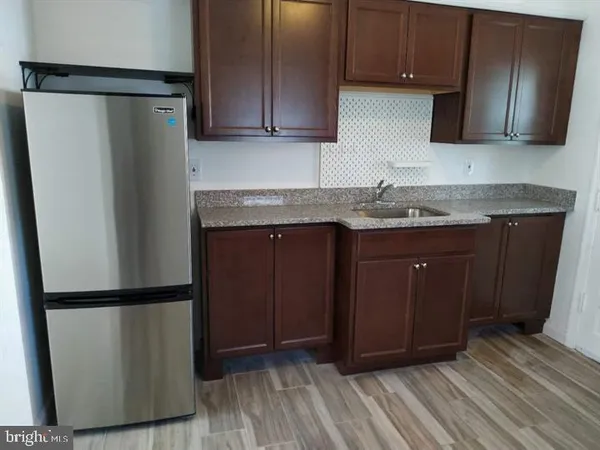 a kitchen with stainless steel appliances granite countertop a refrigerator and a stove