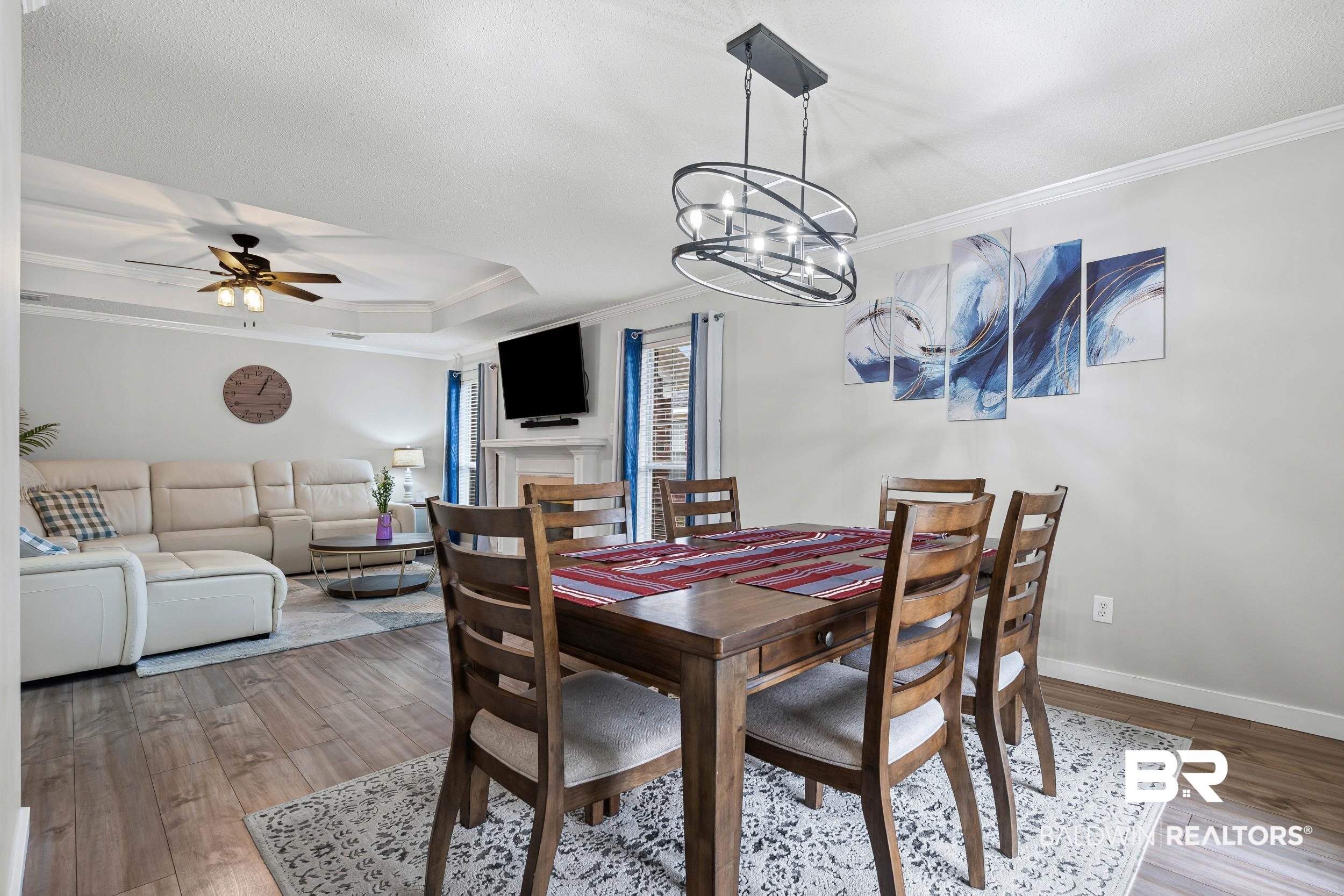 9590 Polo Pl Court Mobile, AL 36695 - Photo 5 of 22 Dining room featuring ornamental molding, light wood-style floors, ceiling fan, a chandelier, and a tray ceiling