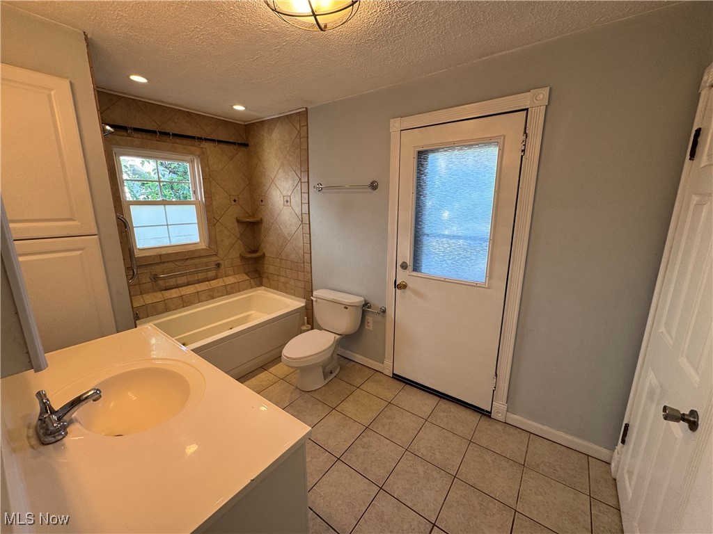 2425 7th Street Northwest Canton, OH 44708 - Photo 13 of 19 Full bathroom featuring a textured ceiling, shower / washtub combination, light tile patterned flooring, and vanity