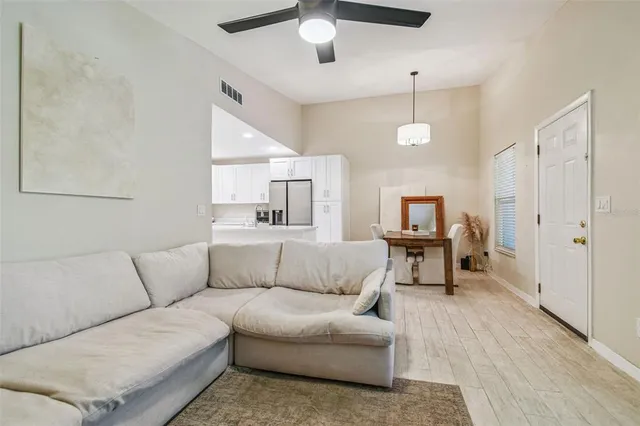 a living room with furniture and a ceiling fan
