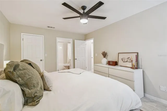 a bedroom with a large bed and a chandelier