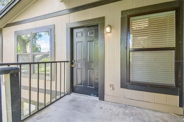 a view of a porch of a house with a door and wooden floor