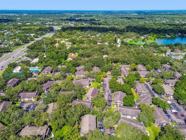 an aerial view of residential houses with outdoor space and trees