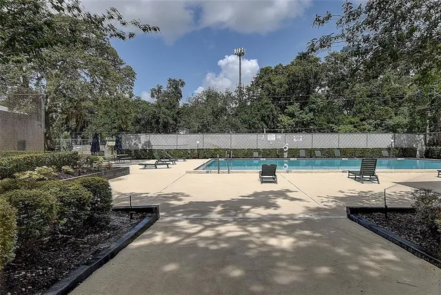 a view of a swimming pool with a patio and a yard
