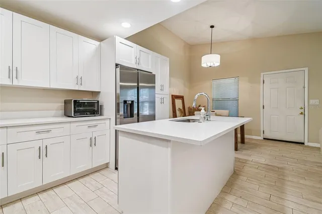 a kitchen with kitchen island a sink appliances and cabinets