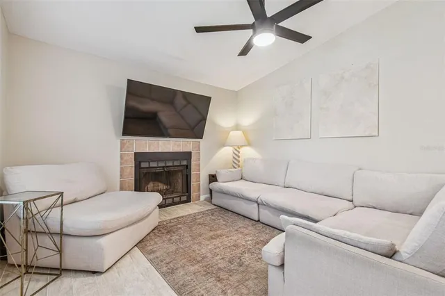 a living room with furniture a fireplace and a flat screen tv