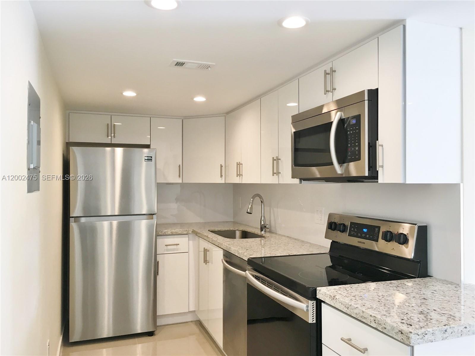4709 Northwest 7th Street, Unit 1079 Miami, FL 33126 - Photo 1 of 28 a kitchen with appliances a sink and a refrigerator