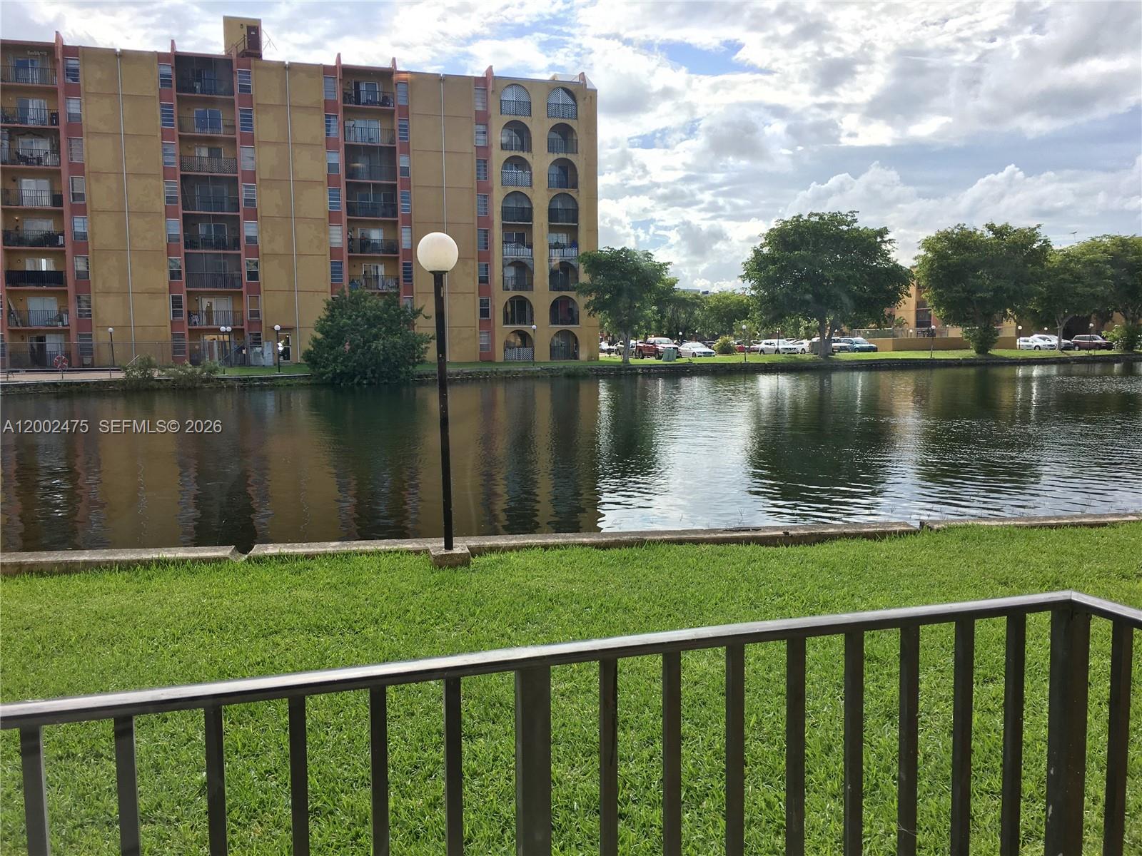 4709 Northwest 7th Street, Unit 1079 Miami, FL 33126 - Photo 2 of 28 a view of a lake with a big yard and a large building