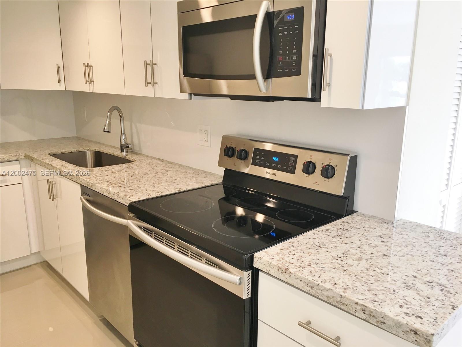 4709 Northwest 7th Street, Unit 1079 Miami, FL 33126 - Photo 3 of 28 a kitchen with a stove and a microwave
