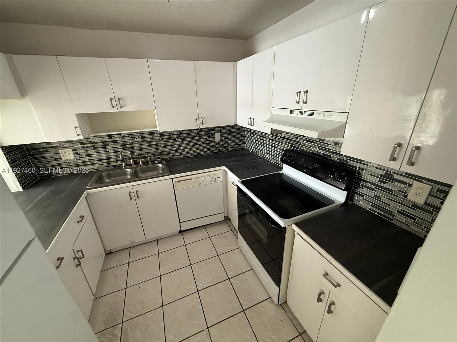 1900 West 68th Street, Unit G308 Hialeah, FL 33014 - Photo 1 of 10 a stove top oven sitting inside of a kitchen