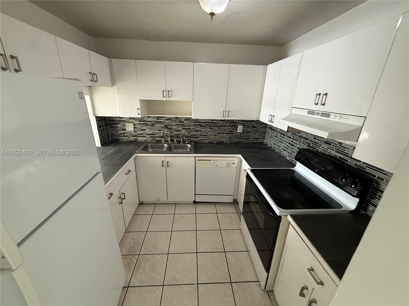 1900 West 68th Street, Unit G308 Hialeah, FL 33014 - Photo 2 of 10 a kitchen with a stove sink and cabinets