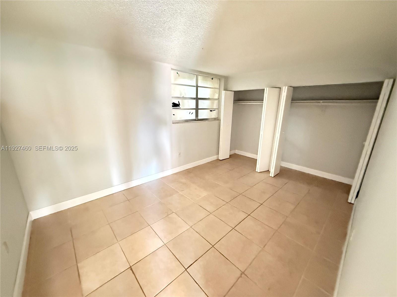 1900 West 68th Street, Unit G308 Hialeah, FL 33014 - Photo 6 of 10 a view of an empty room with a window