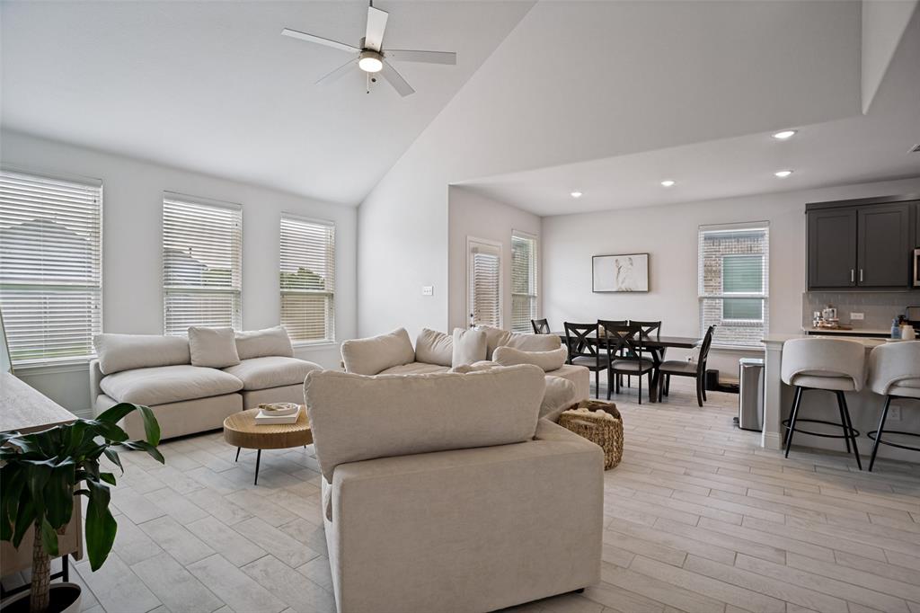3115 Giovanni Point Princeton, TX 75407 - Photo 8 of 26 Open-concept living space featuring vaulted ceilings, a ceiling fan, and light wood-finish flooring