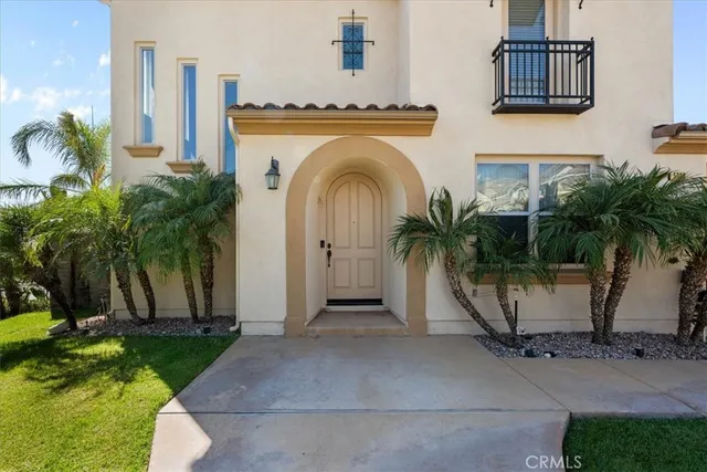 a view of a house with a palm tree next to a road