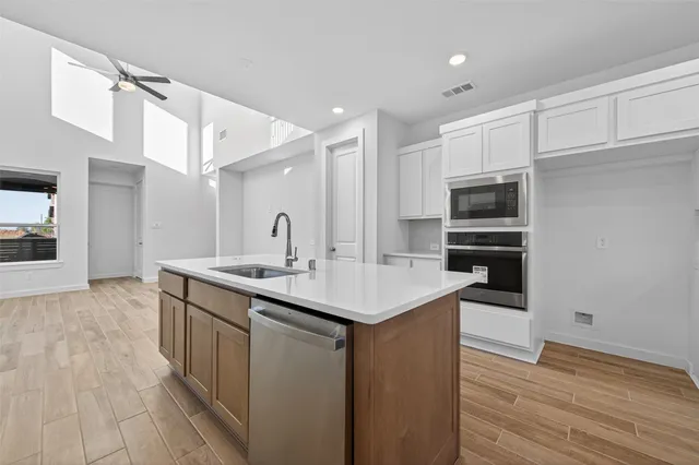 a kitchen with stainless steel appliances a sink and a refrigerator
