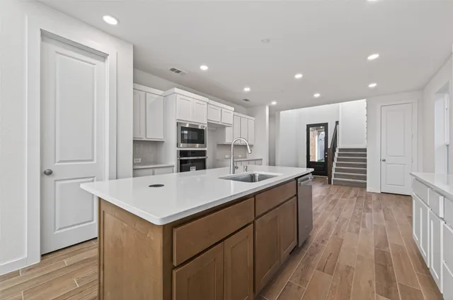 a kitchen with kitchen island a sink appliances and cabinets