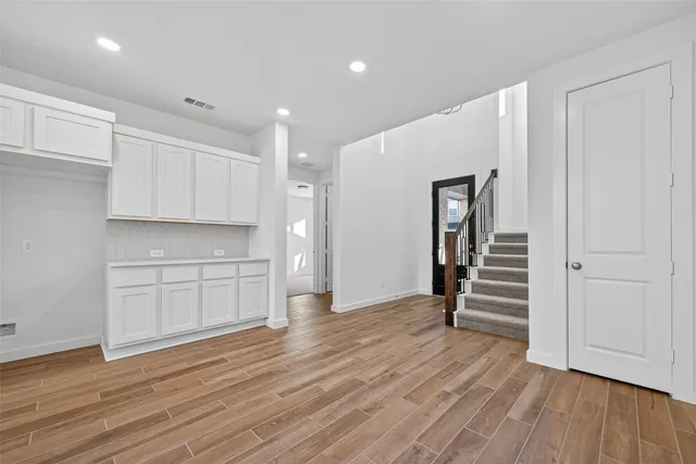 a view of a kitchen with wooden floor and stairs