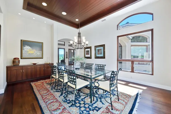 a dining room with furniture a chandelier and a rug