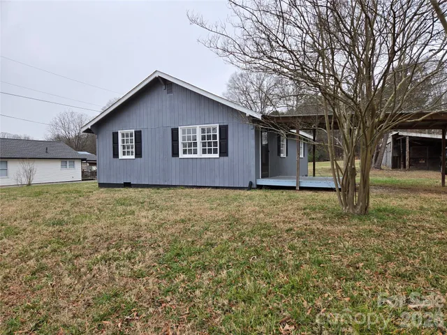 a brick house with a yard and large trees