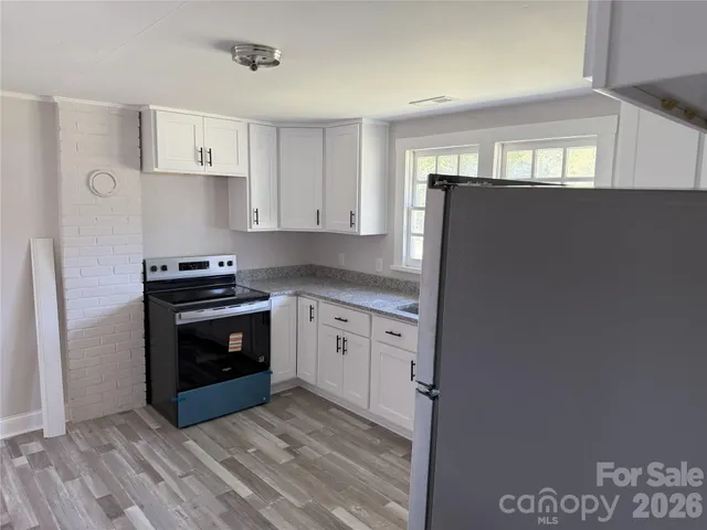 a kitchen with granite countertop a sink cabinets and stainless steel appliances