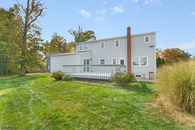 a backyard of a house with plants and large tree