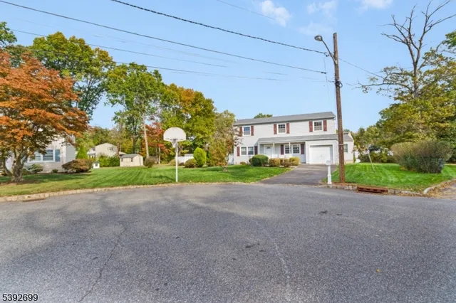 a view of a house with a big yard and large trees