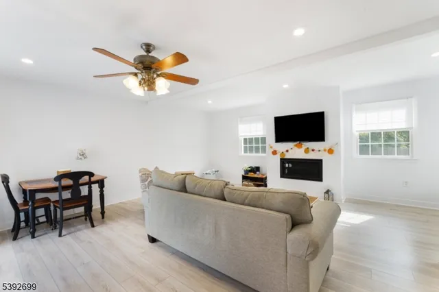 a living room with furniture and a flat screen tv with wooden floor