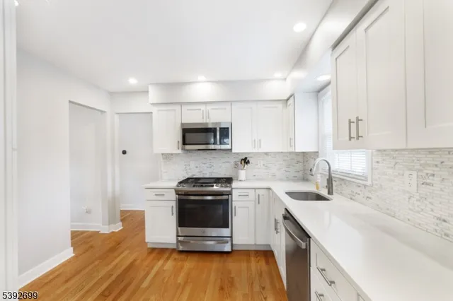 a kitchen with a sink stove and white cabinets