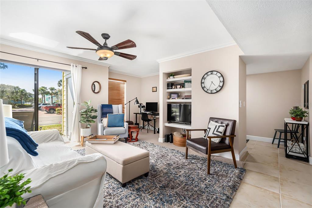 455 Alt 19, Unit 65 Palm Harbor, FL 34683 - Photo 2 of 16 a living room with furniture a clock and a large window