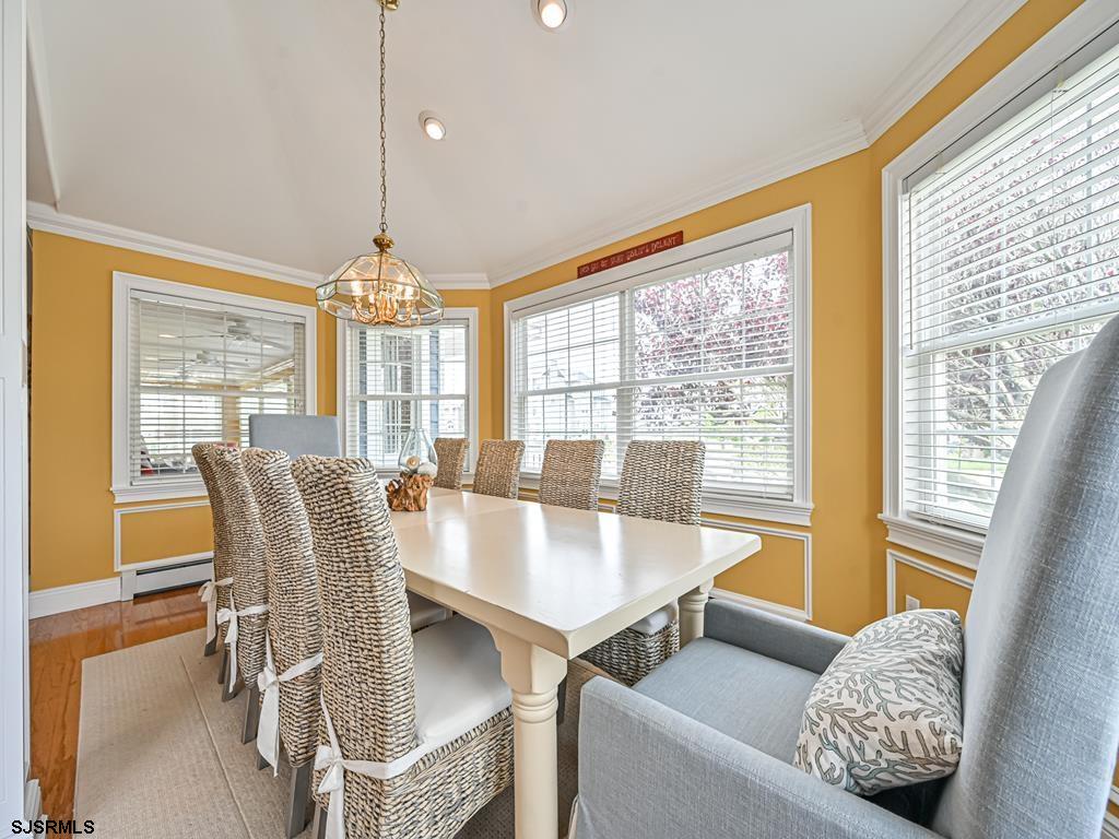 2304 Ocean Avenue Brigantine, NJ 08203 - Photo 12 of 27 a dining room with furniture a chandelier and wooden floor
