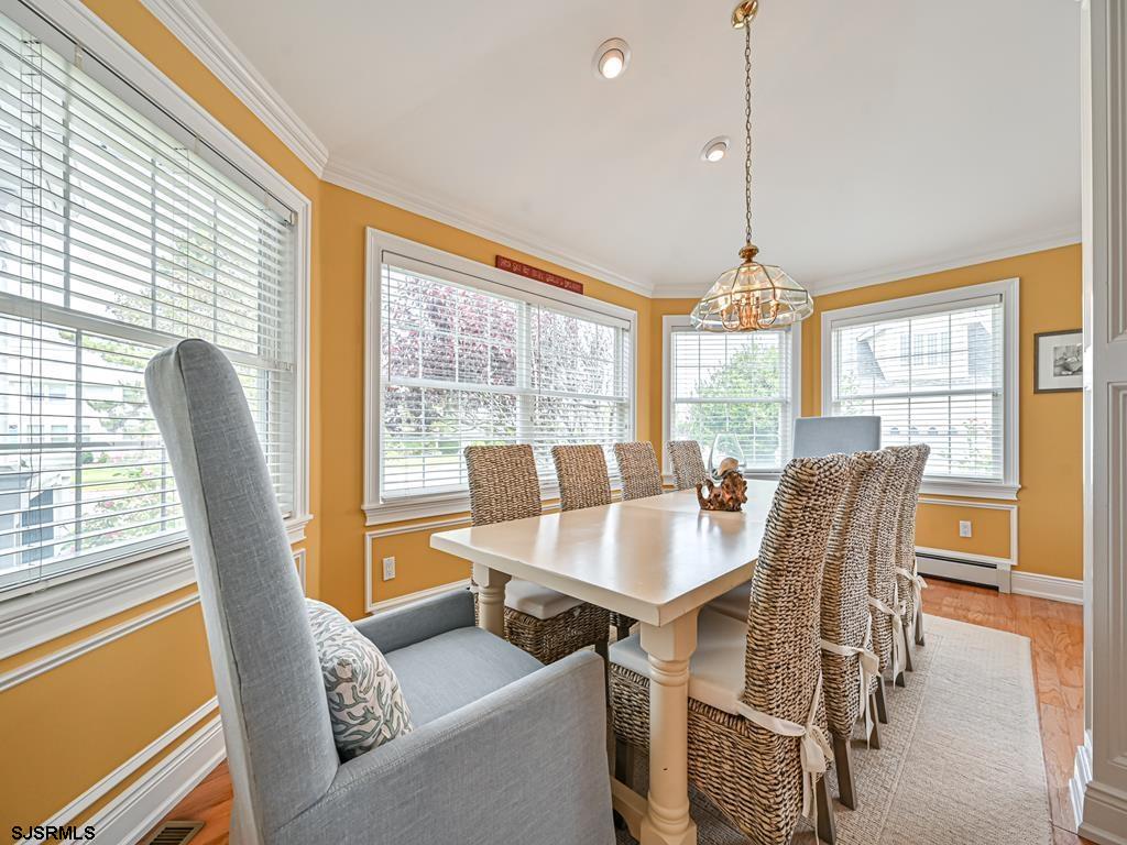 2304 Ocean Avenue Brigantine, NJ 08203 - Photo 13 of 27 a dining room with furniture a chandelier and wooden floor