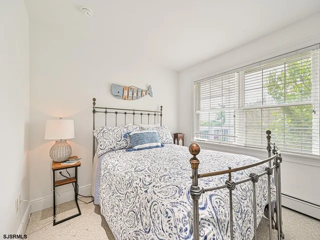 a bedroom with a bed and a table in it with window