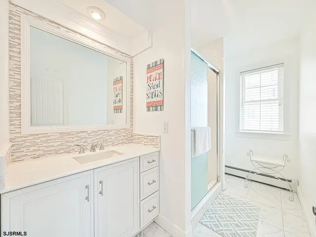 a bathroom with a sink a mirror and a shower