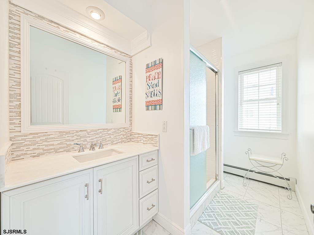 2304 Ocean Avenue Brigantine, NJ 08203 - Photo 25 of 27 a bathroom with a sink a mirror and a shower