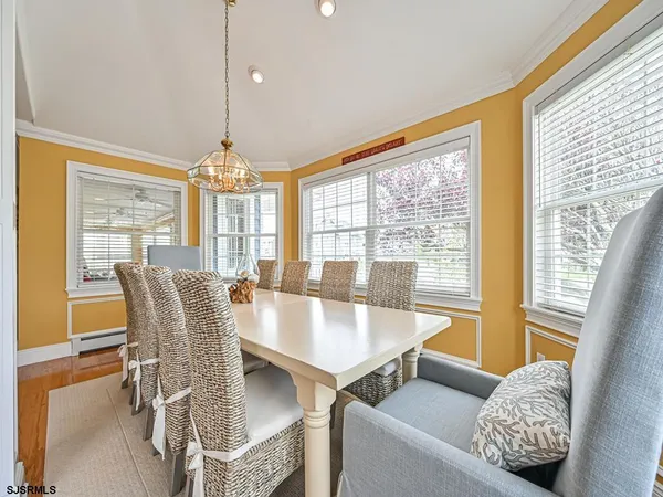a dining room with furniture a chandelier and wooden floor