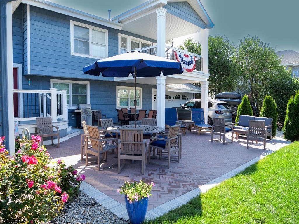 2304 Ocean Avenue Brigantine, NJ 08203 - Photo 3 of 27 a view of a dining tables and chairs in patio with a table and chairs under an umbrella