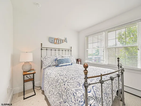 a bedroom with a bed and a table in it with window