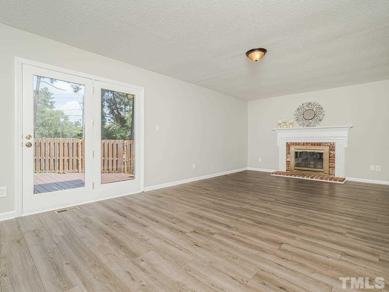 1901 Grove Point Court Raleigh, NC 27609 - Photo 11 of 26 a view of empty room with wooden floor and fireplace