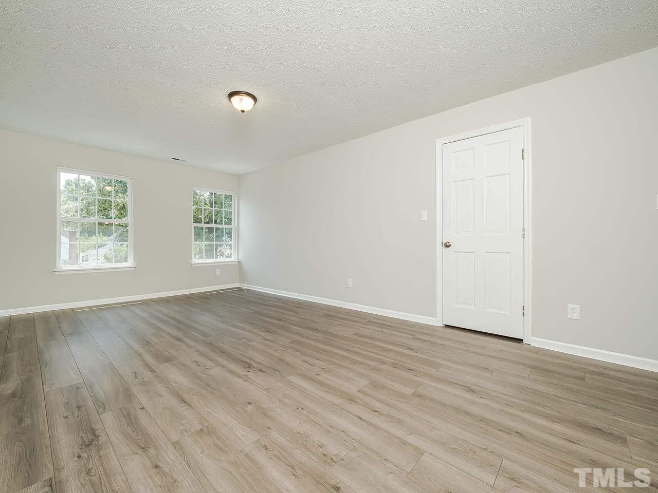 1901 Grove Point Court Raleigh, NC 27609 - Photo 13 of 26 an empty room with wooden floor and windows