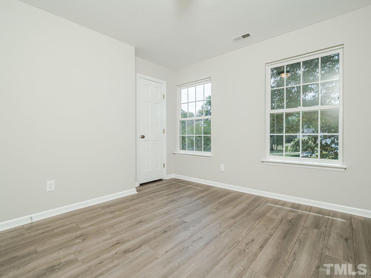 1901 Grove Point Court Raleigh, NC 27609 - Photo 17 of 26 an empty room with wooden floor and windows