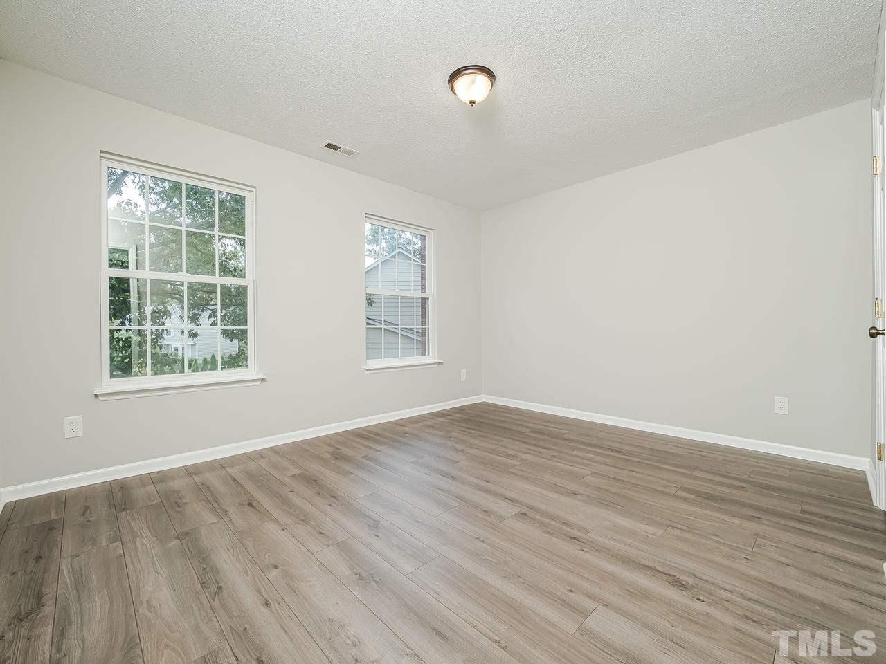 1901 Grove Point Court Raleigh, NC 27609 - Photo 18 of 26 an empty room with wooden floor and windows