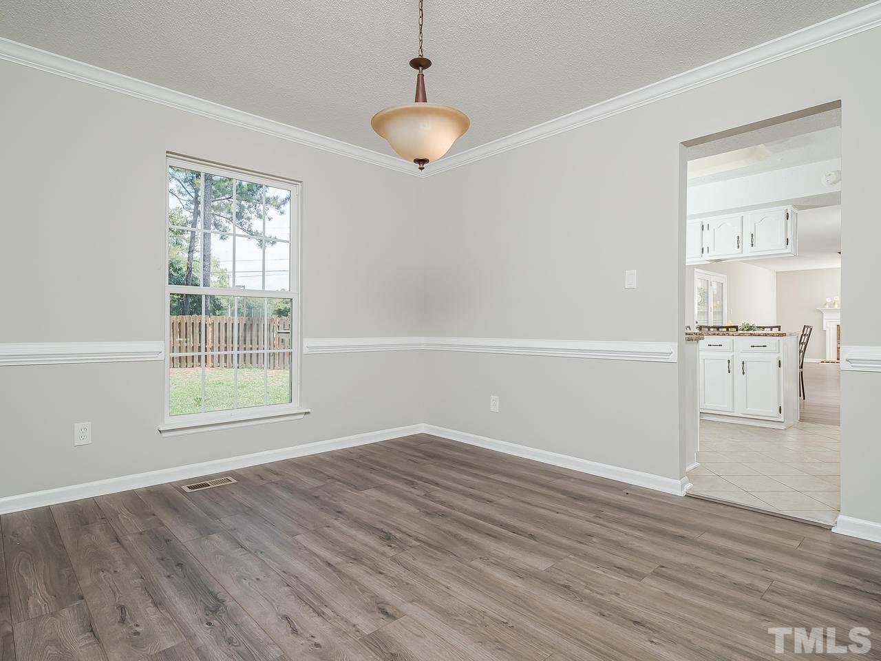 1901 Grove Point Court Raleigh, NC 27609 - Photo 7 of 26 an empty room with wooden floor and windows