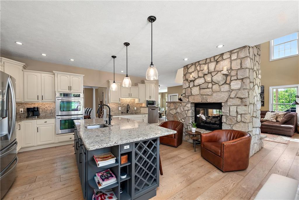 548 Lang Road Sewickley, PA 15143 - Photo 7 of 49 a living room with furniture a fireplace and a kitchen view