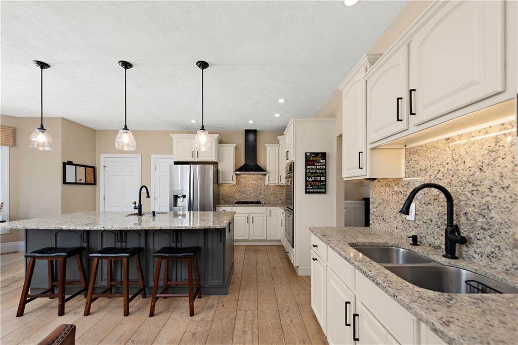 548 Lang Road Sewickley, PA 15143 - Photo 9 of 49 a kitchen with stainless steel appliances kitchen island a white counter space a sink and cabinets