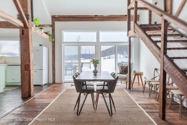 a dining room with furniture and a floor to ceiling window