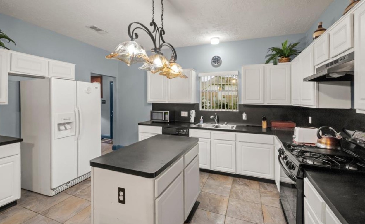 15919 Timber Chase Drive Houston, TX 77082 - Photo 3 of 6 a kitchen with a sink a stove and refrigerator