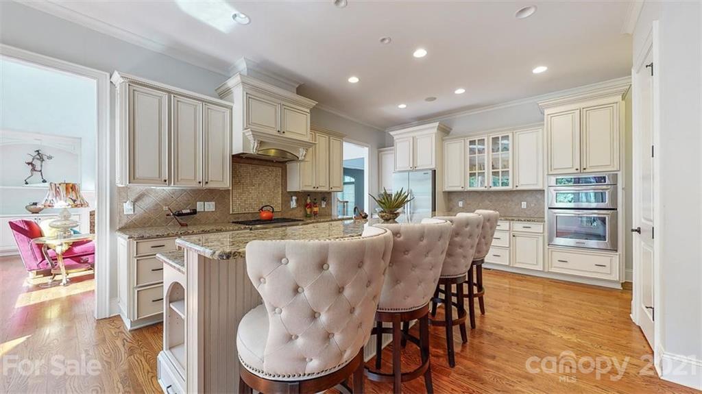 8116 Balcony Bridge Road Huntersville, NC 28078 - Photo 13 of 31 a kitchen with stainless steel appliances granite countertop a stove top oven a sink refrigerator and white cabinets with wooden floor