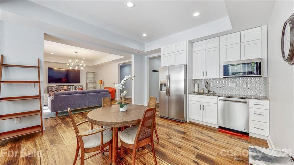 8116 Balcony Bridge Road Huntersville, NC 28078 - Photo 29 of 31 a kitchen with stainless steel appliances kitchen island granite countertop a kitchen island a stove a table and chairs